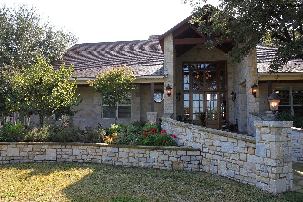 Custom Texas limestone home with covered porch and landscaping built by Tincher's Custom Homes in Mineral Wells, TX