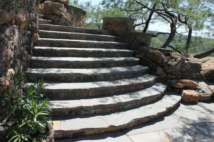 Curved flagstone staircase with native stone risers and retaining walls — outdoor project by Tincher's Custom Homes